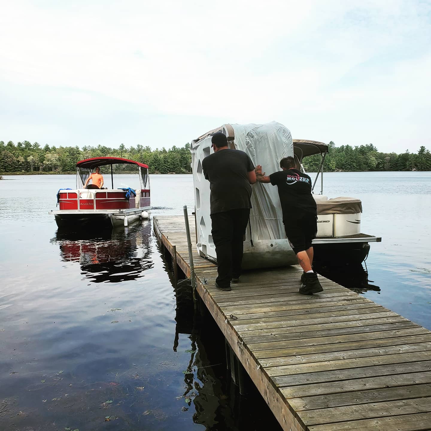 Guys pushing hot tub towards boat